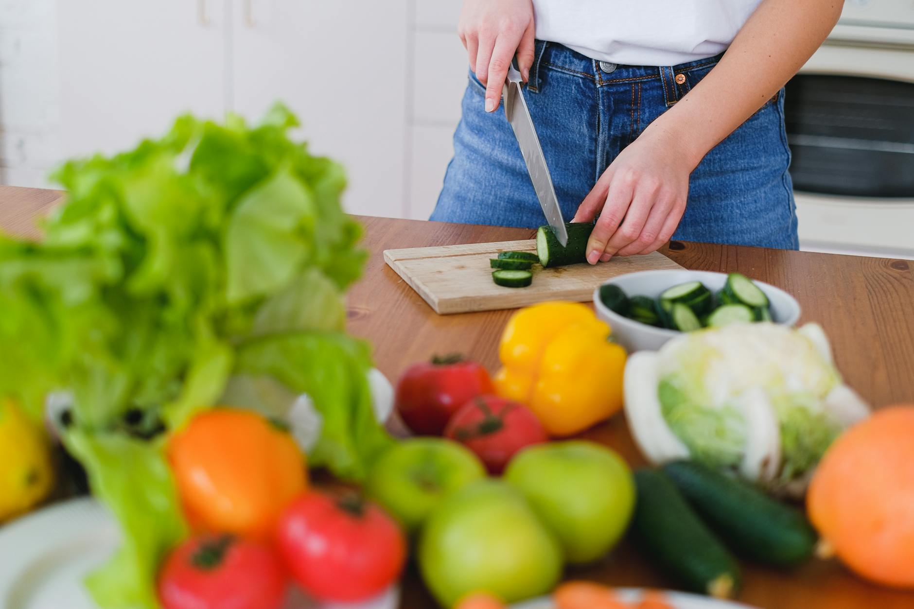 person slicing a cucumber